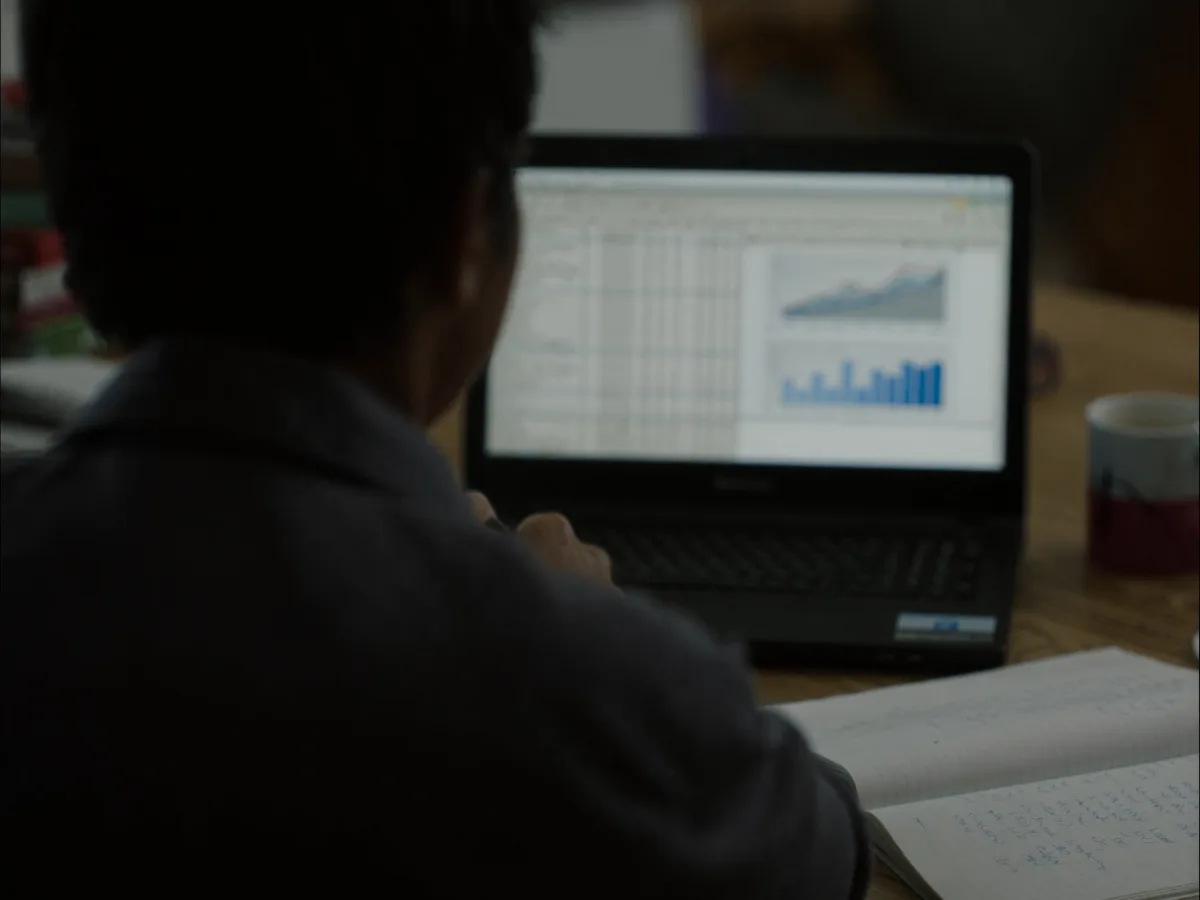 Cost spreadsheet and notes on a desk during a business case evaluation