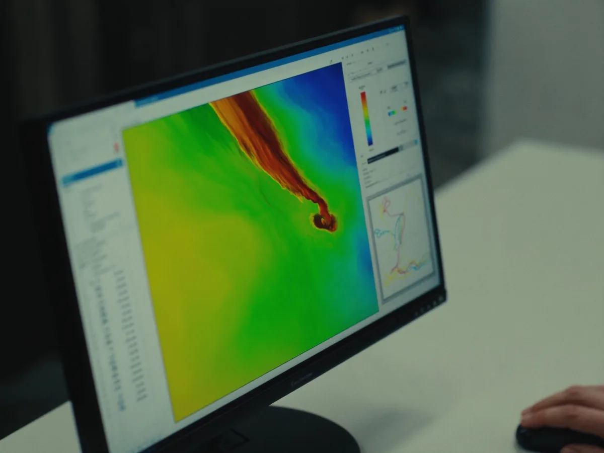 Monitor showing an FEA simulation heatmap on a 3D part